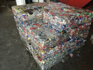Aluminum cans are compacted and bound together for transport.